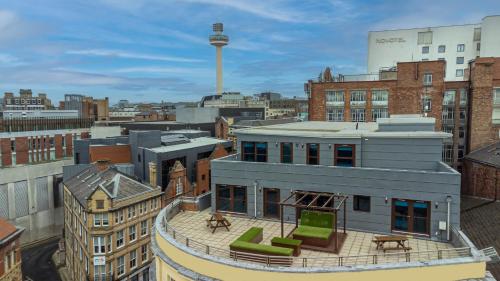 a building with green chairs and tables on top of it at Posh Pads - Liverpool 1 - Apart-Hotel in Liverpool