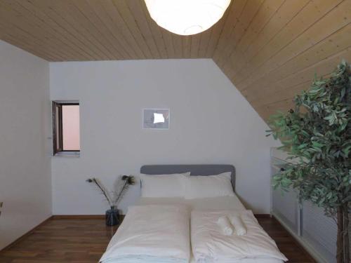 a bed in a room with a wooden ceiling at MONTEURWOHNUNG - Gesamtes Apartment in Göppingen