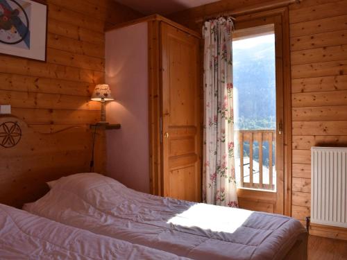 - une chambre avec un lit et une fenêtre dans une cabane en rondins dans l'établissement Chalet 10 personnes à Méribel avec Sauna, Cheminée et Garage - FR-1-180-568, à Les Allues