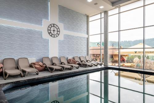 - un groupe de chaises assises à côté de la piscine dans l'établissement Hotel Podgorie Spa, à Bukovel