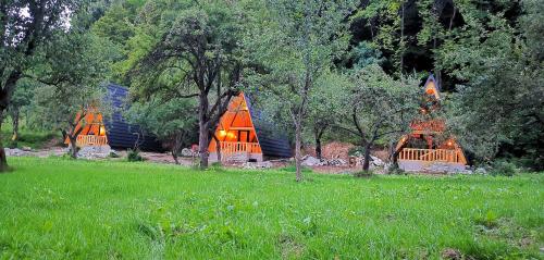 uma casa laranja no meio de um campo em Casa - Cabana Tip A Frame, Cerna, Vaideeni, Valcea em Cerna
