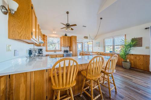 a kitchen with wooden cabinets and a bar with chairs at Sound Waves in Duck