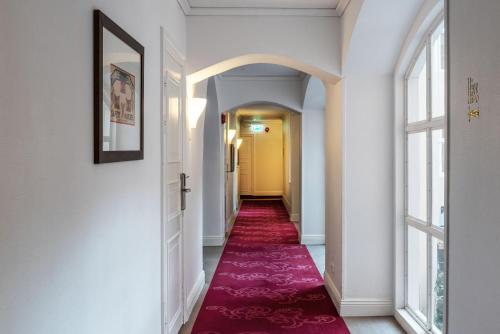 a corridor with a red carpet in a hallway at Home Hotel Victoria in Jönköping