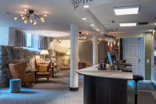 a lobby with a bar with chairs and a desk at Home Hotel Victoria in Jönköping