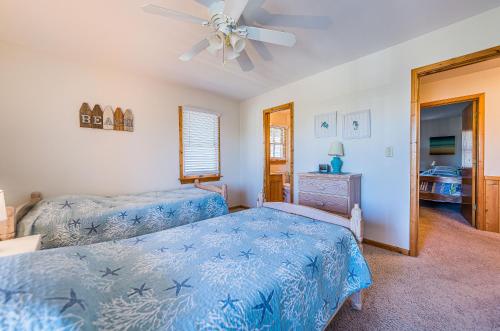 a bedroom with two beds and a ceiling fan at Sound Waves in Duck