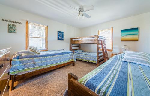 a bedroom with two beds and a bunk bed at Sound Waves in Duck