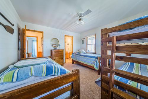 a bedroom with two beds and a bunk bed at Sound Waves in Duck