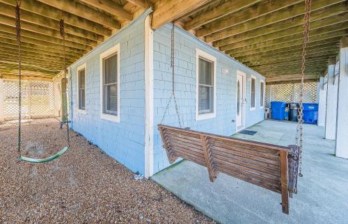 a porch swing hanging from the side of a house at Sound Waves in Duck