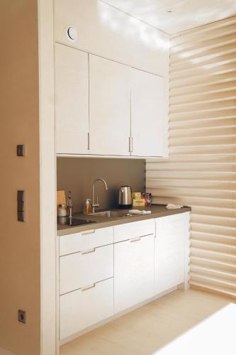 a kitchen with white cabinets and a sink at Floater in Dudelange