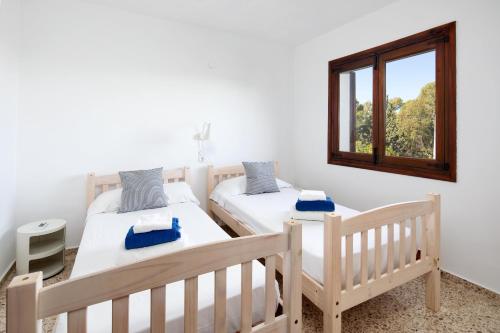 1 dormitorio con 2 camas y ventana en Villa Marta, en Denia
