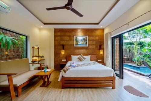 a bedroom with a bed and a couch and a window at Olala An Bang Villa in An Bang