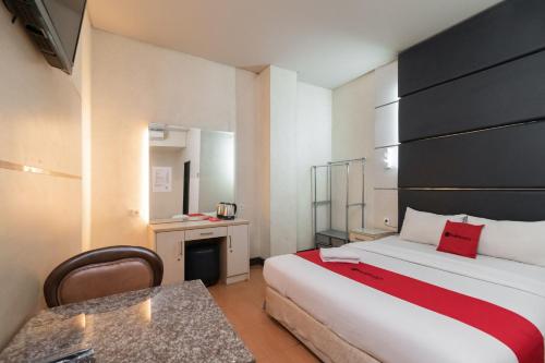 a hotel room with a bed and a table at RedDoorz at Jalan Gunung Sahari in Jakarta