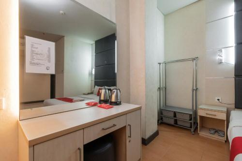 a room with a kitchen with a sink and a bed at RedDoorz at Jalan Gunung Sahari in Jakarta