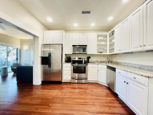 uma cozinha com armários brancos e electrodomésticos de aço inoxidável em Elegance & Charm 27 Steps To Old Christ Church em Pensacola