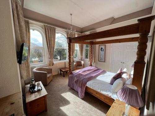 a bedroom with a large bed with a wooden frame at Broughton Craggs Hotel in Cockermouth