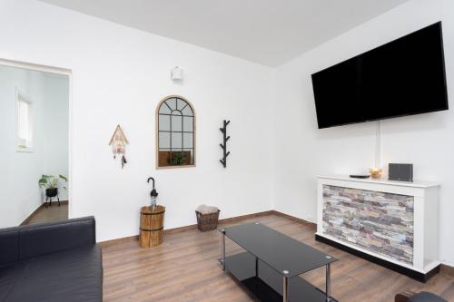 uma sala de estar com uma televisão de ecrã plano na parede em Casa Laura y Pancho em Fasnia