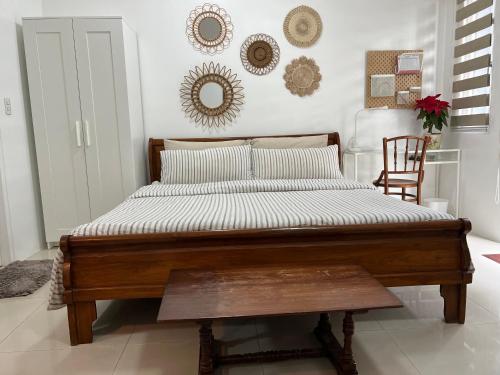 a bed with a wooden frame in a room at Telly's Studio Across NAIA3 in Manila