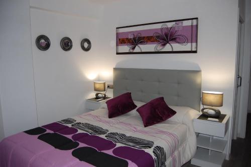 - une chambre avec un lit violet et blanc et 2 lampes dans l'établissement piso blanco, à Jávea