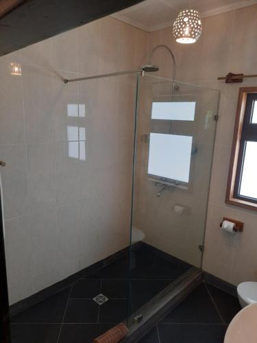 a shower with a glass door in a bathroom at Domaine Les Rochers in La Digue
