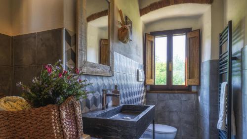 a bathroom with a sink and a mirror at LA VECCHIA PIEVE 8, Emma Villas in Castiglione della Valle