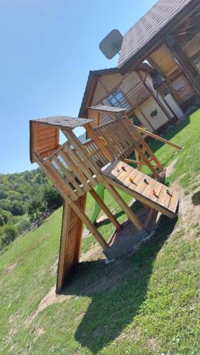 a wooden picnic table sitting on top of a hill at Pensiunea Romosan in Cucuiş