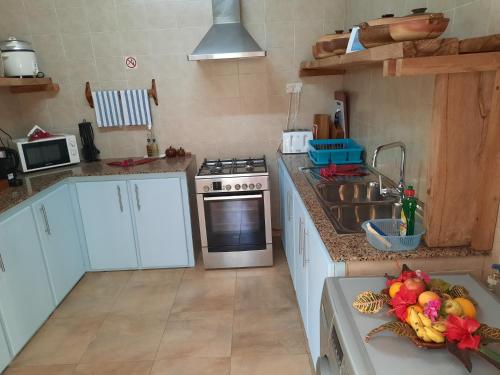 a kitchen with white cabinets and a sink at Domaine Les Rochers in La Digue