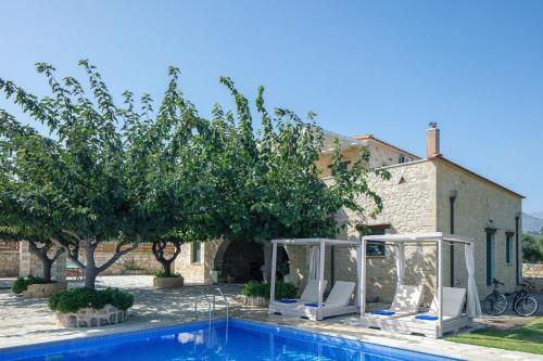 a villa with a swimming pool in front of a house at Villa Pinelopi in Asprouliánoi
