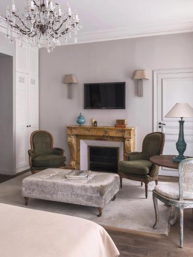 a living room with a couch and a fireplace at New Hotel Roblin in Paris