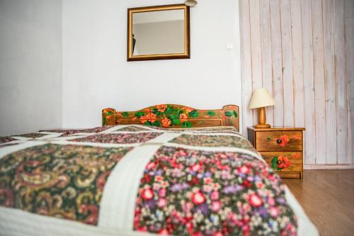 a bedroom with a bed with a colorful blanket at Ostoja Wigierski in Mikolajewo
