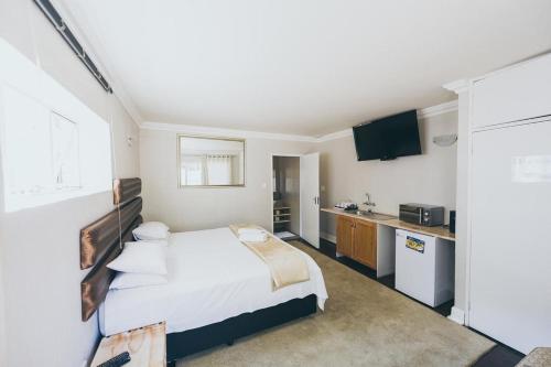 a hotel room with a bed and a kitchen at B and B Sandton in Johannesburg