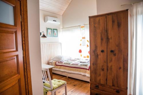 a small bedroom with a bed and a wooden door at Ostoja Wigierski in Mikolajewo