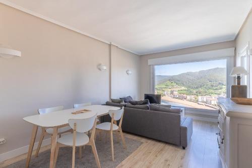 Bakio Seaview V by Aston Rentals في باكيو: غرفة معيشة مع طاولة وأريكة