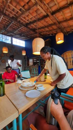 a woman is preparing food on a table at Isange Paradise Resort in Ruhengeri
