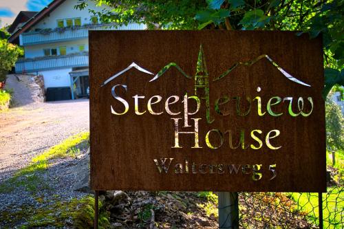 un cartello che legge le abitazioni dei vicini di strada di Steepleview House, Schwarzwaldblick Apartment - spacious & peaceful a Bad Peterstal-Griesbach