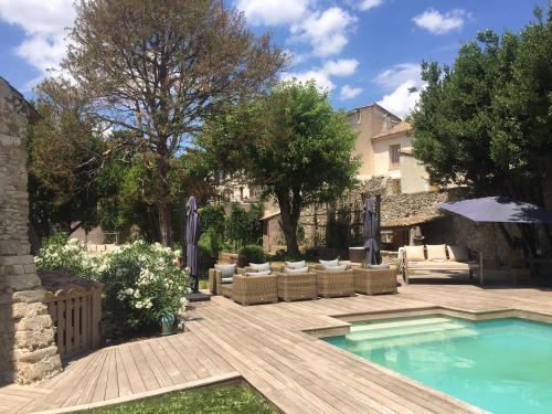 a backyard with a swimming pool and a wooden deck at La Chapelle sur la Sorgue in LʼIsle-sur-la-Sorgue