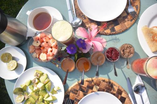 a table topped with plates of food and drinks at Isange Paradise Resort in Ruhengeri