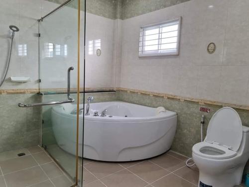 een badkamer met een bad, een toilet en een douche bij Sun Poolvilla Bangsaray in Bang Sare