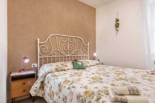 1 dormitorio con 1 cama con colcha de flores en L'antica corte apt Mara, en Levico Terme