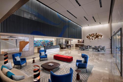 a lobby with blue and red chairs and a waiting room at Hyatt Place Vadodara in Vadodara