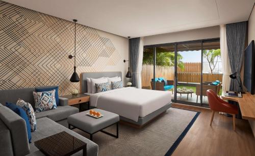 a bedroom with a bed and a living room at Hyatt Place Vadodara in Vadodara