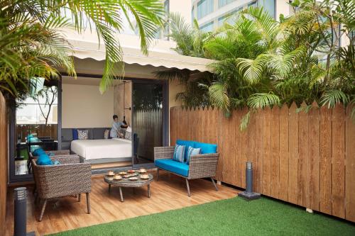 a patio with a bed and chairs and a table at Hyatt Place Vadodara in Vadodara