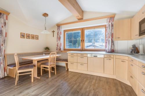 a kitchen with a table and chairs and a window at Ferienwohnung Hörbiger in Wildschönau