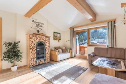 a living room with a fireplace and a couch at Ferienwohnung Hörbiger in Wildschönau
