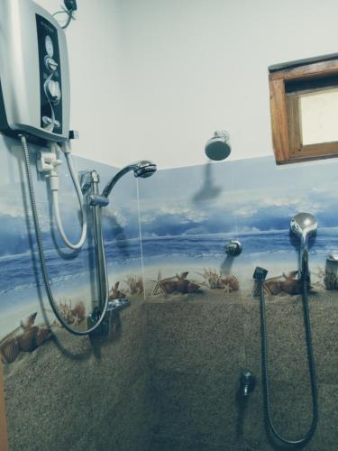 La salle de bains est pourvue d'une douche et d'une peinture murale. dans l'établissement Kasun Hotel, à Koslanda