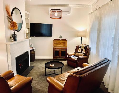 a living room with a couch and a fireplace at Edge17 Waterfront Apartment, plus Cottage with Garden View - Port Fairy in Port Fairy