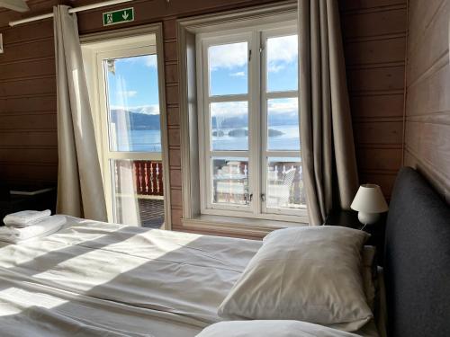 a bedroom with a bed and a large window at Bjørnafjorden Hotell in Osøyro