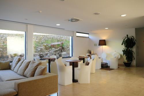 a waiting room with white chairs and tables at HI Alvados - Pousada de Juventude in Alvados