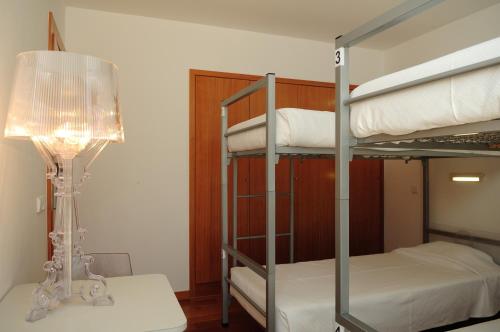 a bedroom with a bunk bed with a lamp and a lampost at HI Alvados - Pousada de Juventude in Alvados