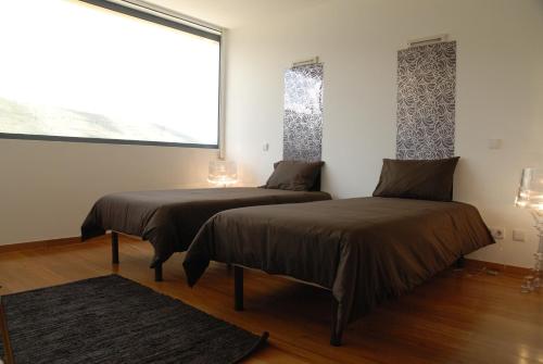 two beds in a room with a window at HI Alvados - Pousada de Juventude in Alvados