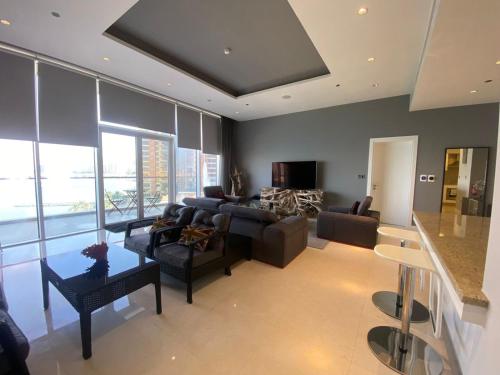 a living room with a couch and a table at Tiara Emerald - 1BR Apartment - Allsopp&Allsopp in Dubai